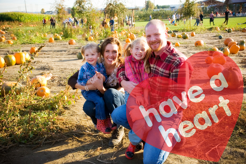 Family in a pumpkin patch with Have a Heart logo
