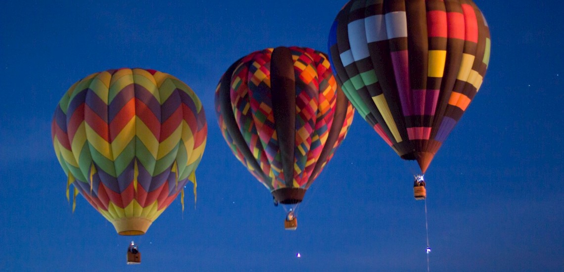 3 hot air balloons floating in the dawn of the morning